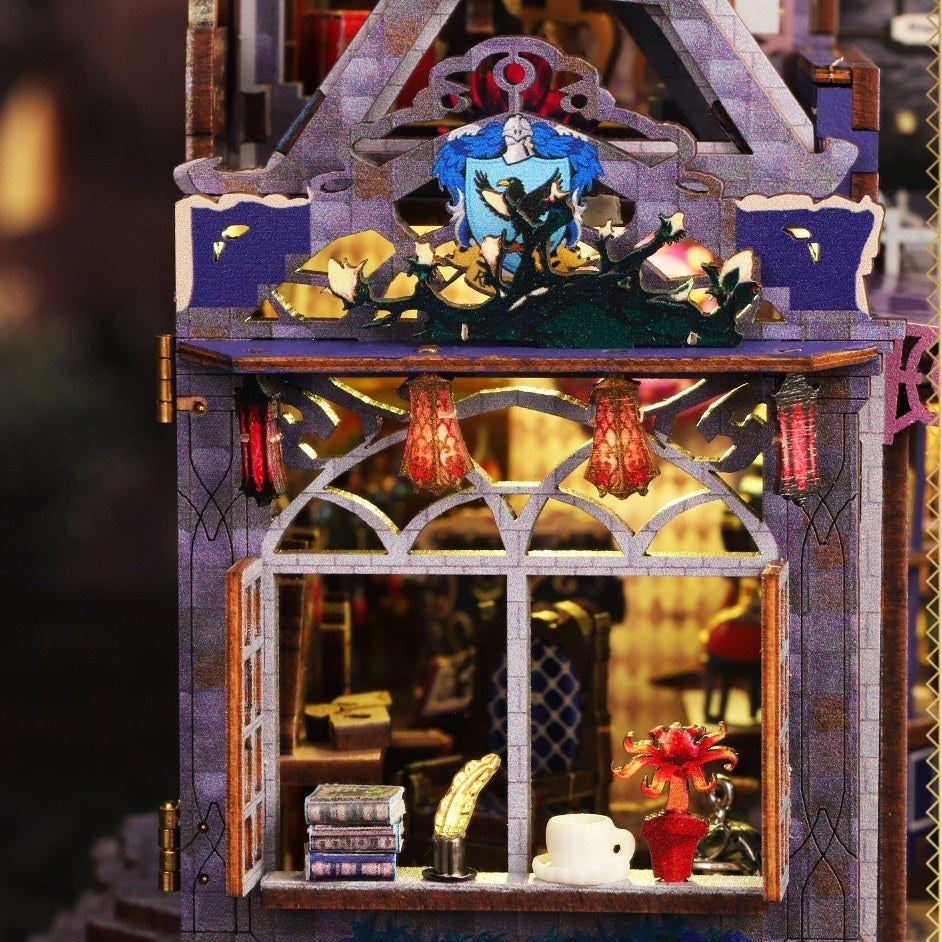 Decorative dollhouse model of a magic house with a character on top, set against a blurred indoor background.