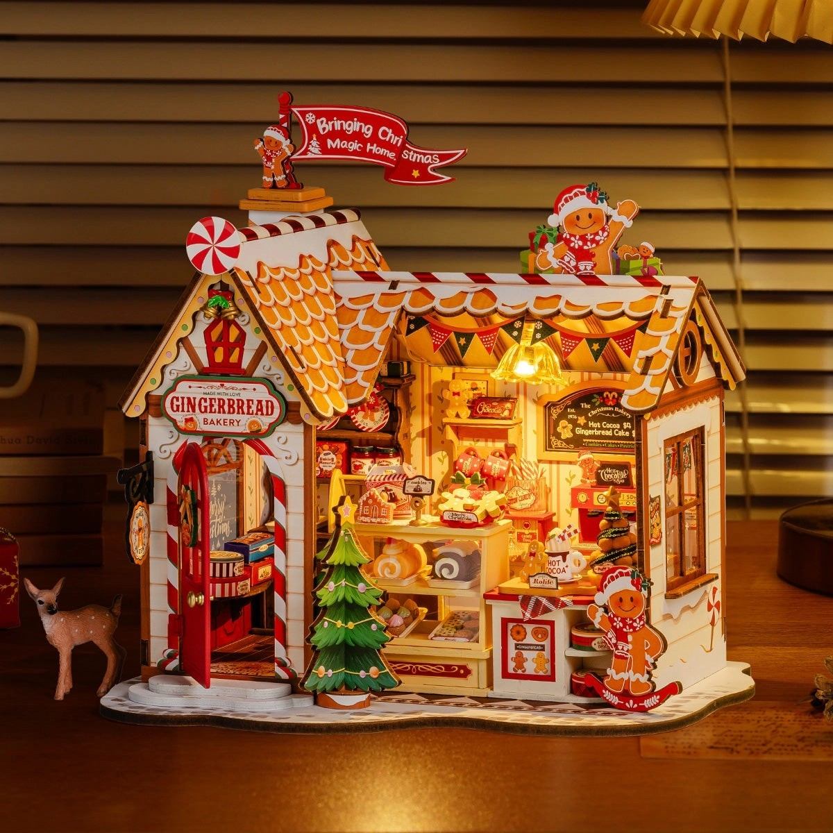 Gingerbread-themed bakery miniature house with lights on a wooden floor