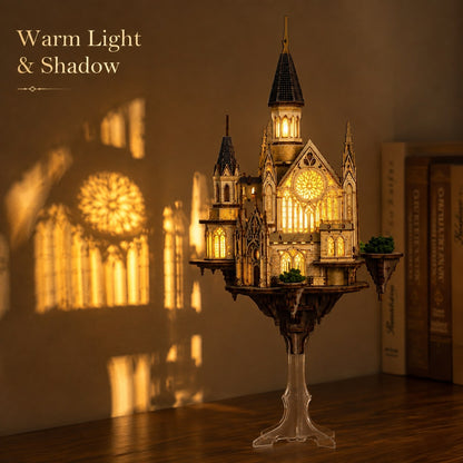 A miniature gothic cathedral puzzle model with warm internal lighting, displayed on a wooden surface with a wall behind it casting a rose window shadow. Text in the top left reads 'Warm Light & Shadow'.
