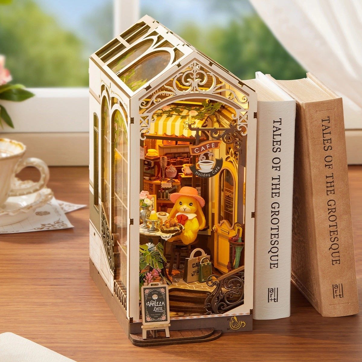 Miniature book nook model of a cafe inside a book with a decorative interior, placed on a wooden surface.