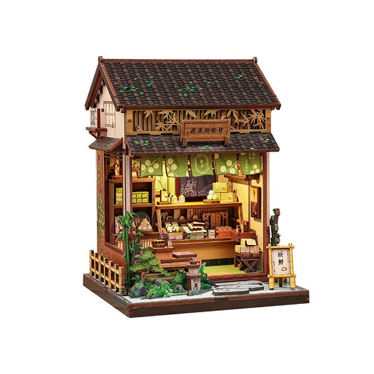 Detailed miniature house model of a traditional Japanese tea house with wooden architecture and greenery.