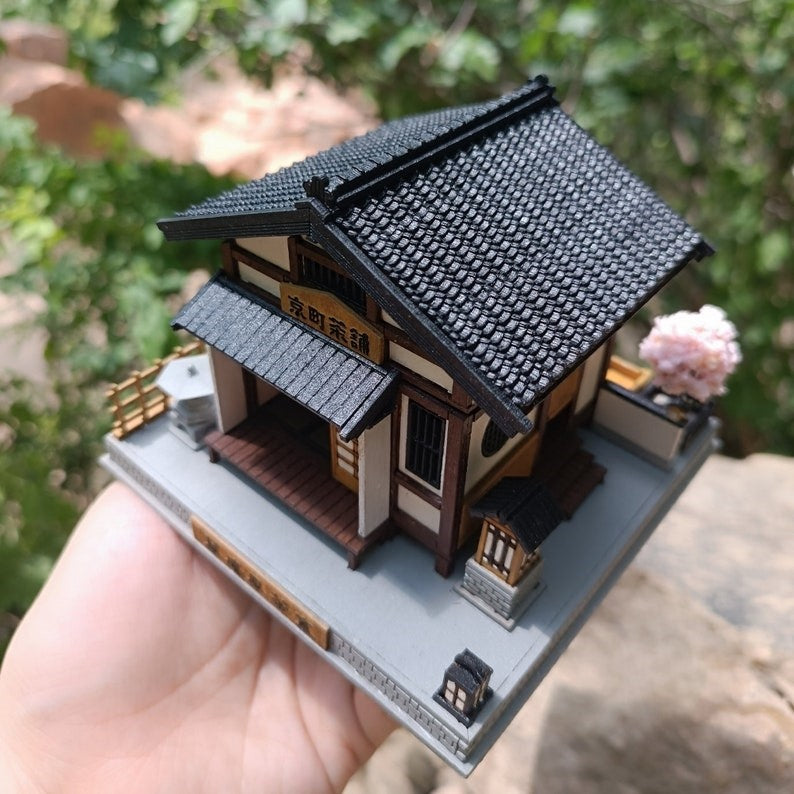 the assembled and painted Japanese Tea House DIY Miniature Dollhouse Kit holding with hands, to showcase its top side view