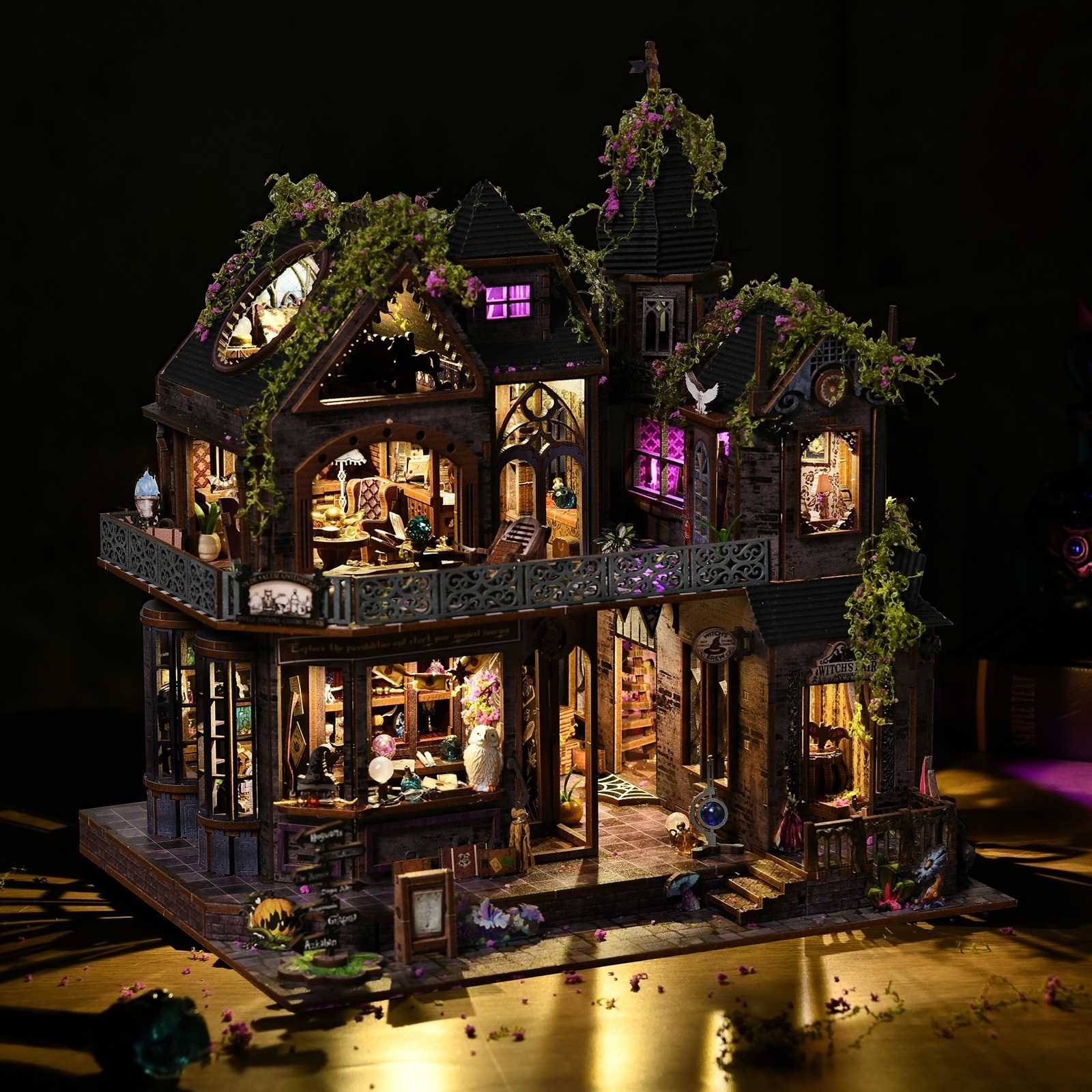 Detailed miniature house model of a haunted house with illuminated interior on a dark background