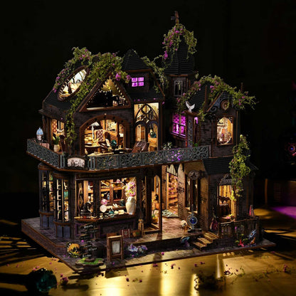 Detailed miniature house model of a haunted house with illuminated interior on a dark background