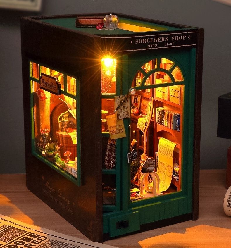 image displaying the finished Magic Diary DIY Book Nook Kit with warm LED light in a table setting