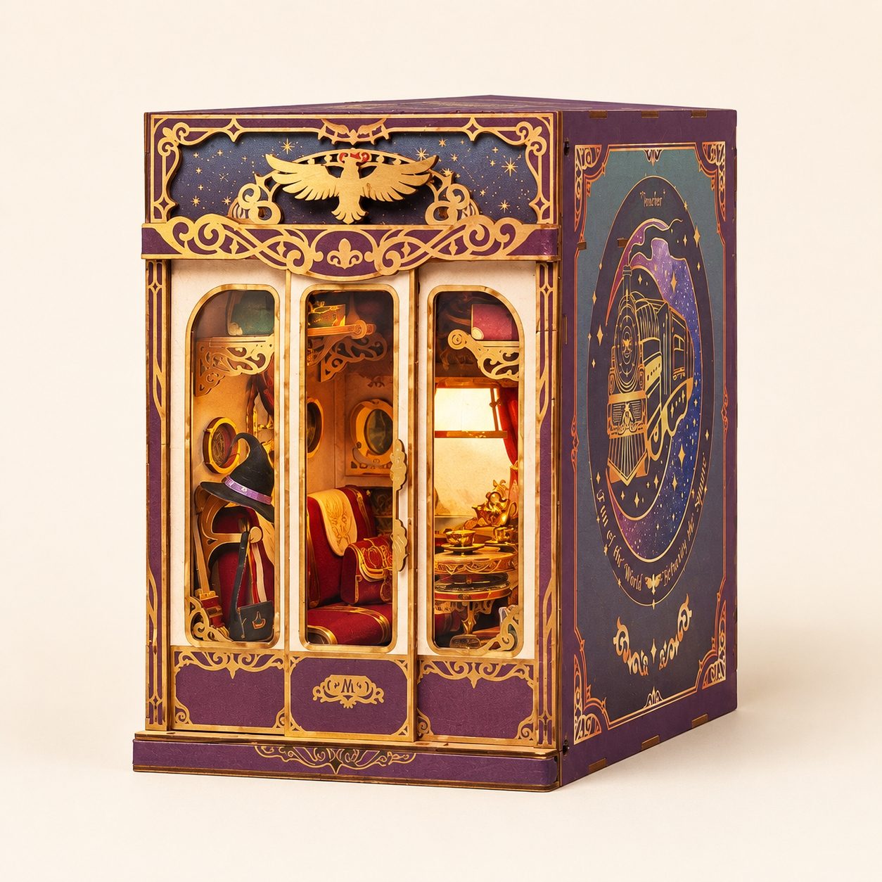 A decorative miniature book nook model resembling a vintage carriage or cabriolet, shown on a plain light beige studio background. The exterior is primarily deep purple with ornate gold detailing, and the interior is illuminated from within, showing red upholstered seats and a warm yellow light.