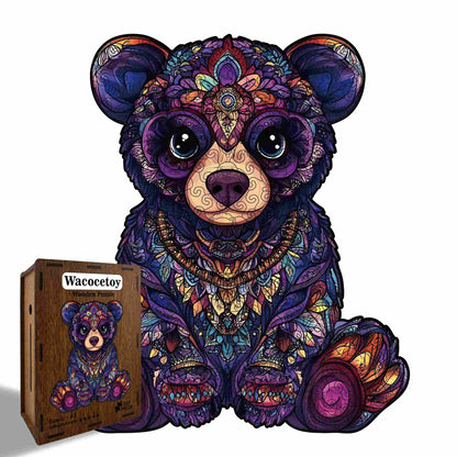 Colorful teddy bear puzzle with intricate patterns next to its packaging on a white background