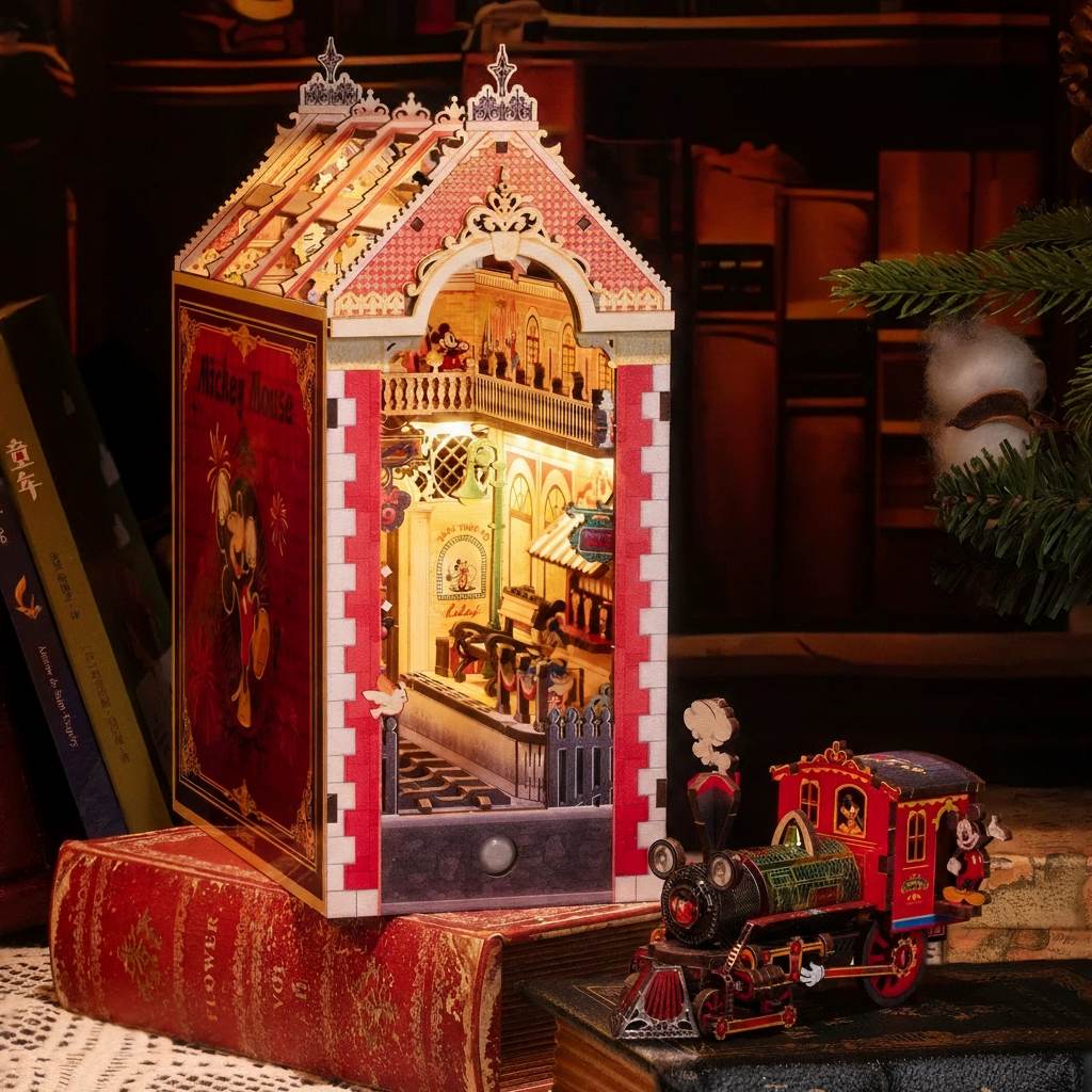 Detailed book nook model of a miniature house with a train station and bookshelf in the background