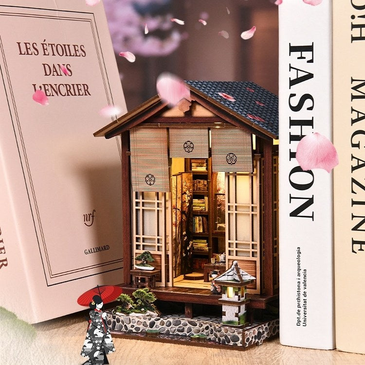 Miniature Japanese-style house with cherry blossoms and books in the background