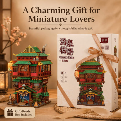A miniature decorative building set shown next to its retail box. The product is a detailed red and green pagoda-style house with lanterns, displayed beside a white box tied with a beige ribbon.