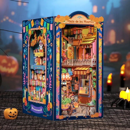 Colorful miniature book nook model of a street scene with shops and decorations, set against a Halloween-themed background.