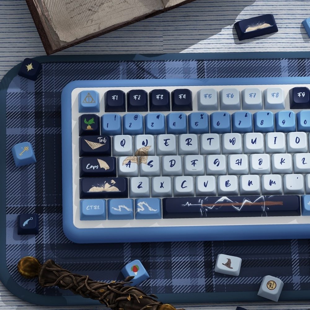 Blue and white keyboard Inspired by one of the iconic Hogwarts house Ravenclaw on a plaid surface with books and a quill.
