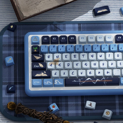 Blue and white keyboard Inspired by one of the iconic Hogwarts house Ravenclaw on a plaid surface with books and a quill.
