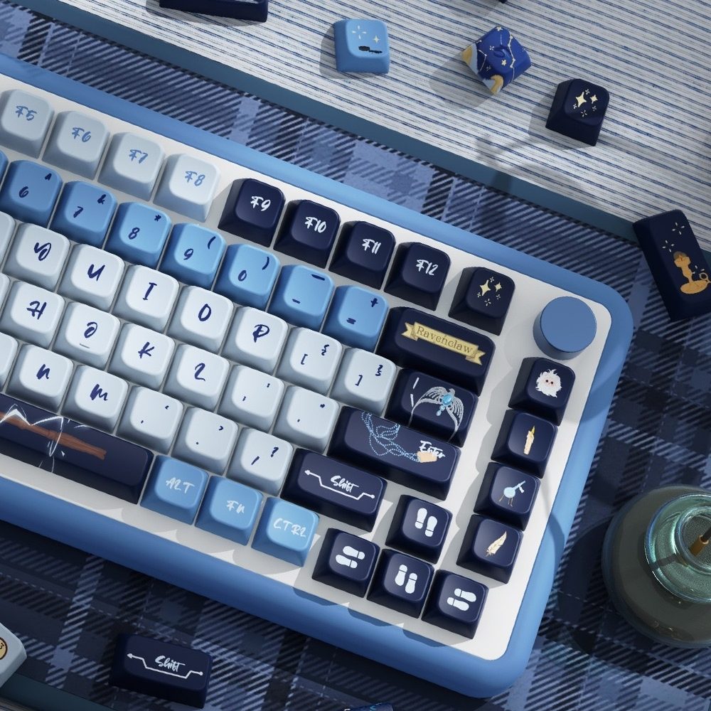 Blue and white keyboard with decorative keycaps Inspired by one of the iconic Hogwarts house Ravenclaw on a checkered tablecloth.