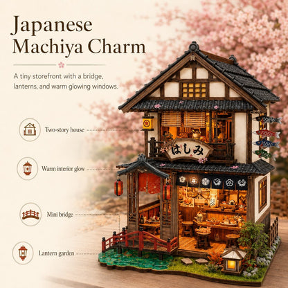A miniature two-story Japanese machiya storefront model with a bridge, lanterns, and warm glowing windows, shown on a tabletop with a blurred cherry-blossom background. Text on the left highlights features: two-story house, warm interior glow, mini bridge, and lantern garden.