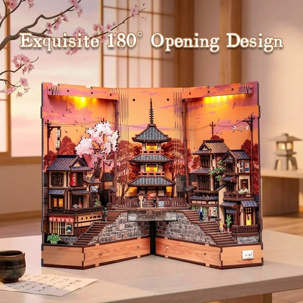 Wooden model of a traditional Japanese house with cherry blossoms and pagoda, illuminated from within.