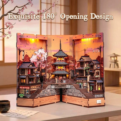 Wooden model of a traditional Japanese house with cherry blossoms and pagoda, illuminated from within.