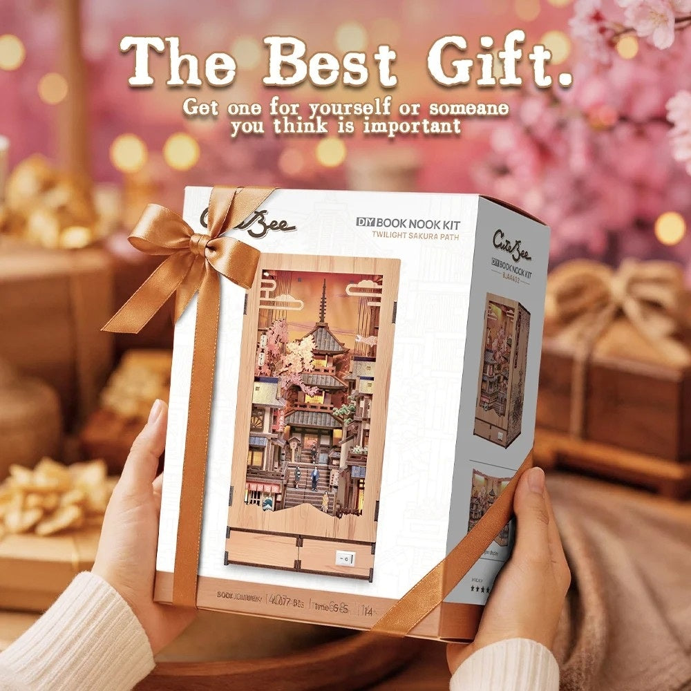 Boxed product of Japanese Sakura Path book nook kit with a decorative bow held by hands