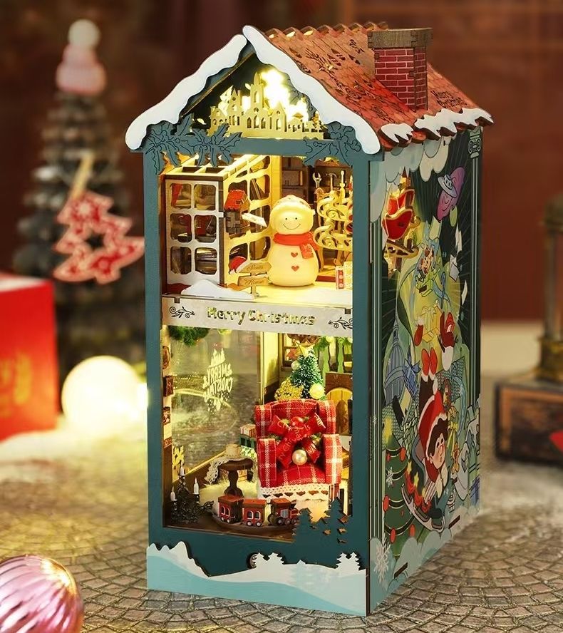 image displaying the assembled Santa's Christmas House DIY Book Nook Kit in a Christmas-themed table setting