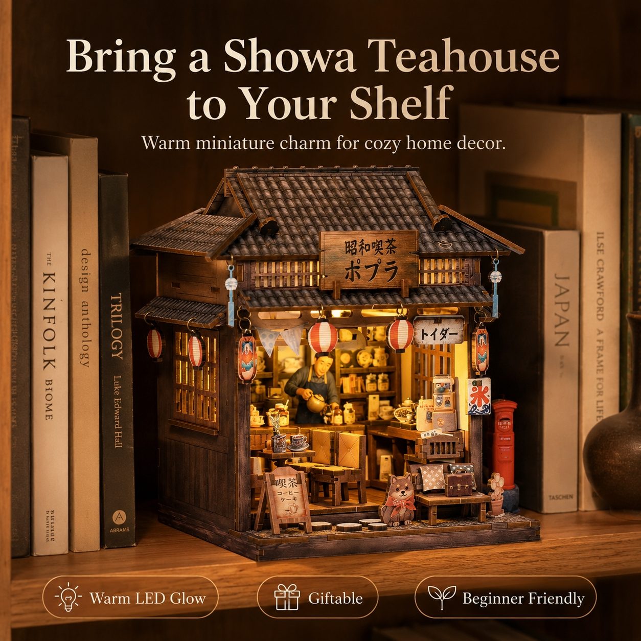 A miniature Japanese tea house shelf decor set displayed on a wooden shelf among books. The product features a detailed dark brown wooden structure with a tiled roof, warm yellow LED lighting from within, red lanterns, and Japanese text details.