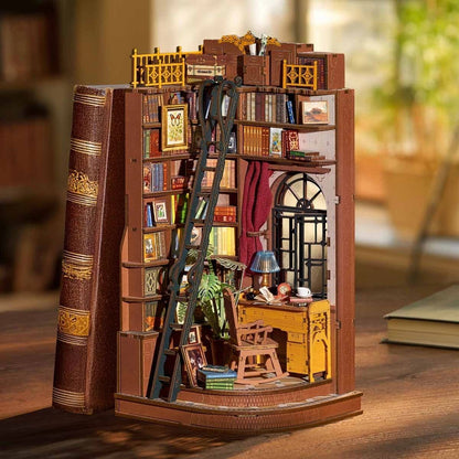 Miniature book nook with books and a desk inside, resembling a cozy study.