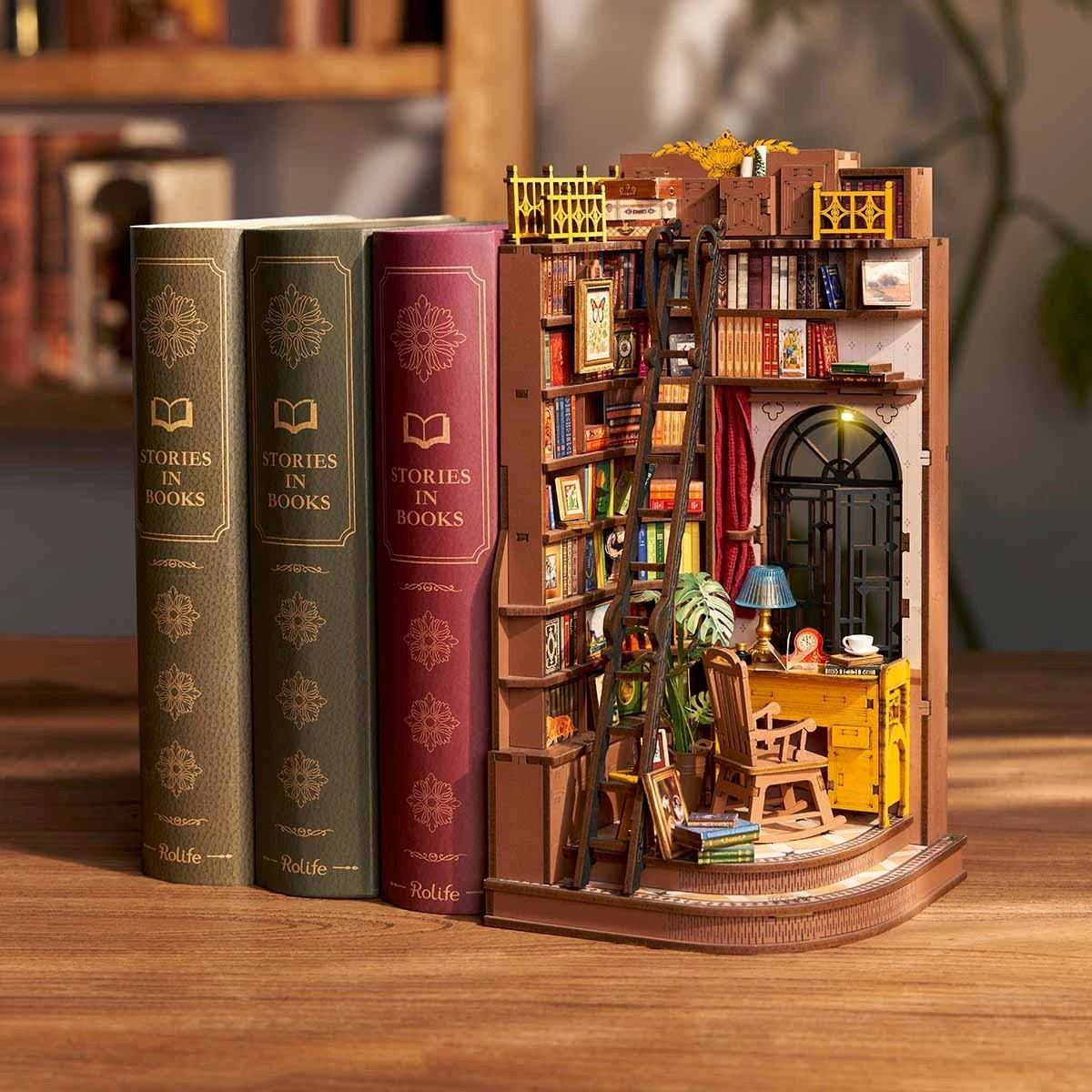 Miniature bookshelf model with books and interior details on a wooden surface