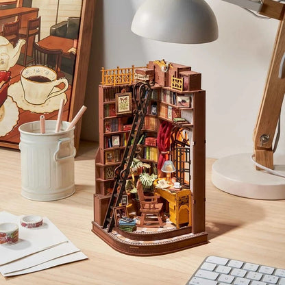 Wooden book nook model of a bookshelf with various items on a desk