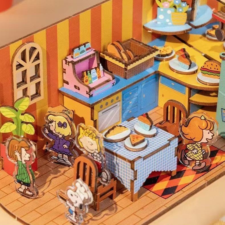 Miniature model of a dinning room with " Peanuts" cartoon characters and food items.
