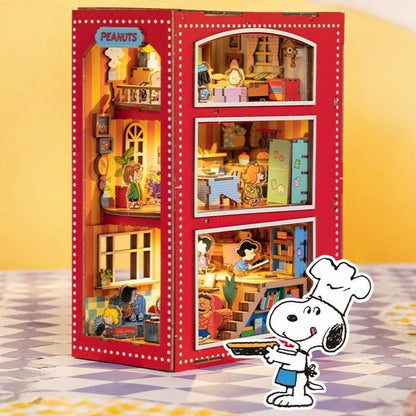 Red book nook with a miniature model of a Peanuts' house interior, featuring Snoopy in a chef's hat.