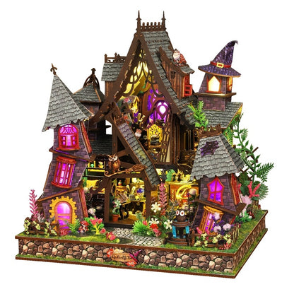Detailed miniature house model of a fairy tale house with lit windows on a white background