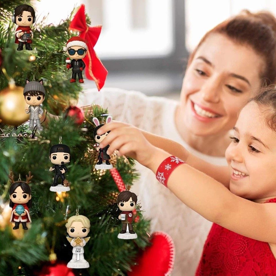 Woman and child decorating a Christmas tree with Funko Pop! figurines.