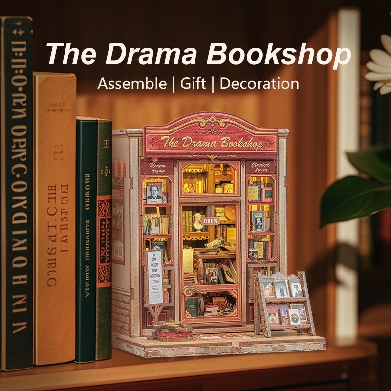 Book Nook Model of a bookshop with 'The Drama Bookshop' branding, surrounded by books on a wooden surface.