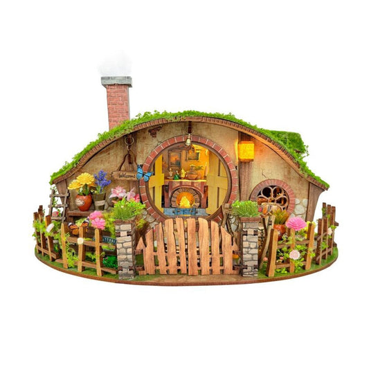 Miniature House of a hobbit house inspired by the Magic Ring House, with a grass roof, wooden door, and garden on a white background