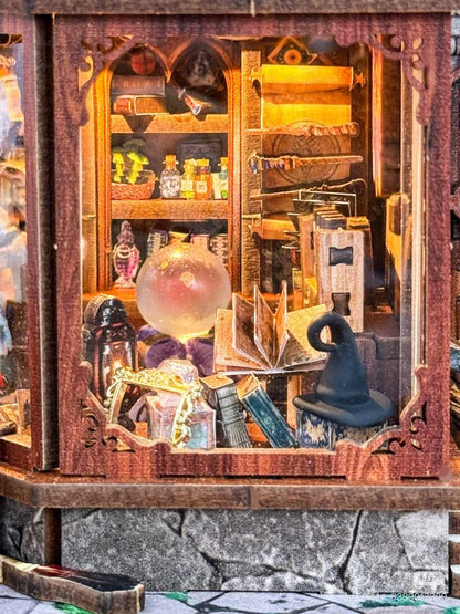 miniature Wooden cabinet with magical items including books, a globe, and potions.