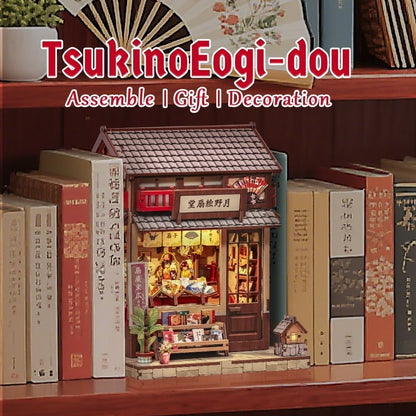Miniature House model of a Japanese storehouse among books with 'TsukinoEogi-dou' branding.