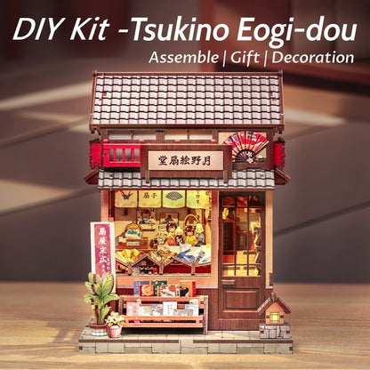 DIY Miniature Craft Kit model of a traditional Japanese building on a wooden surface with text indicating assembly, gift, and decoration.