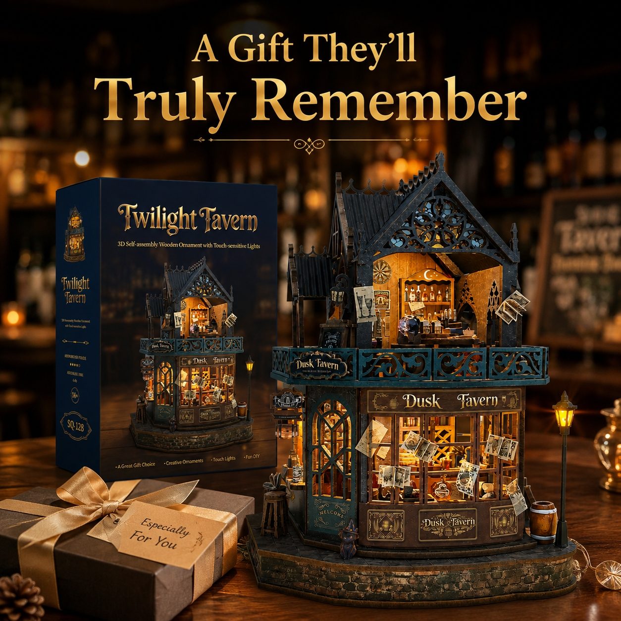 Twilight Tavern DIY wooden model kit shown with its retail box and a wrapped gift box on a wooden table. The main product is a detailed, illuminated miniature tavern structure with dark teal and brown wood tones, warm yellow interior lights, and tiny decorative figures.
