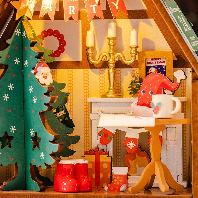 image displaying the miniature living room scene in assembled Twinkling Christmas House DIY Miniature House Kit, including fireplace, Christmas tree, candles