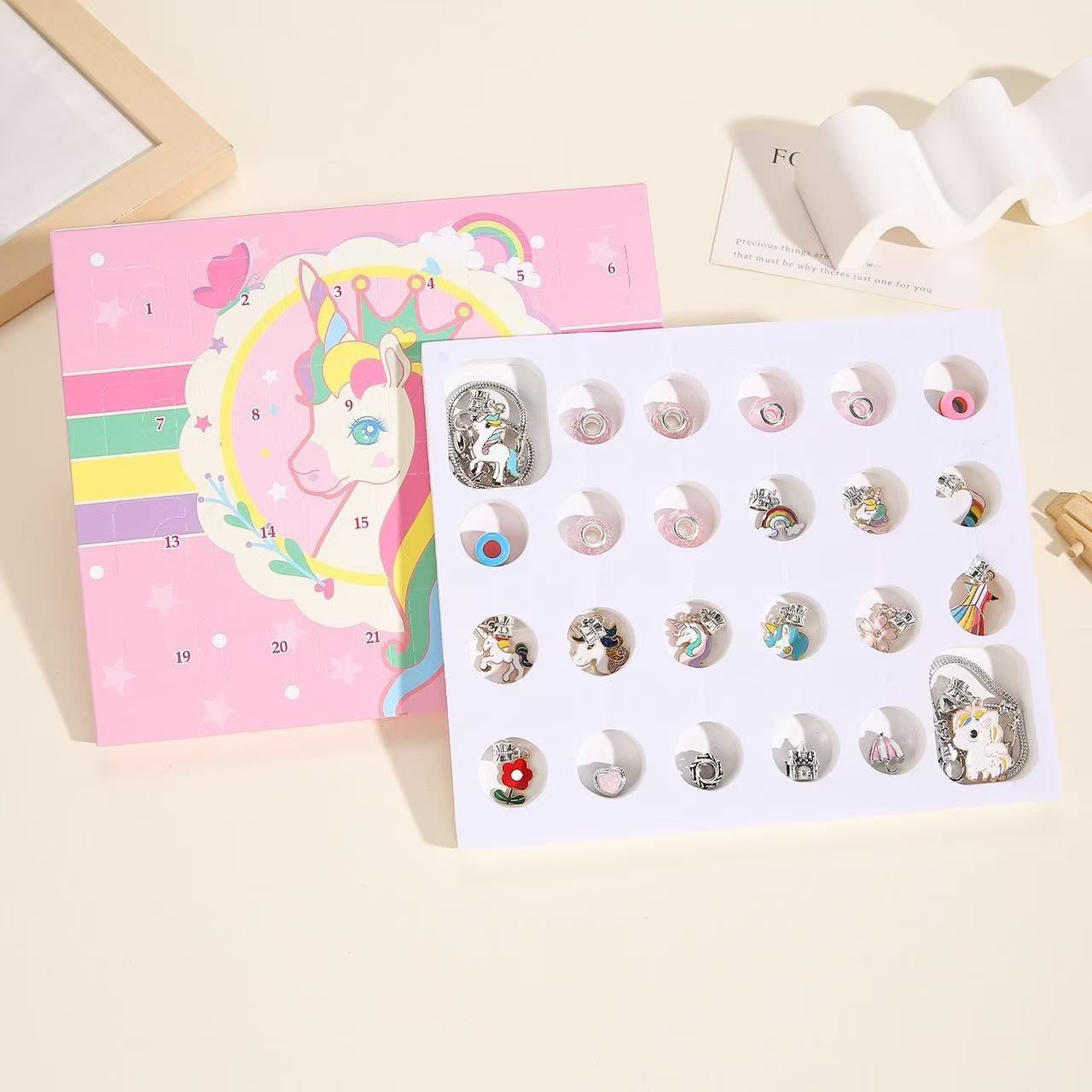 image displaying the charms and bracelets of the Unicorn Advent Calendar Christmas Countdown Bracelet Set in the package box