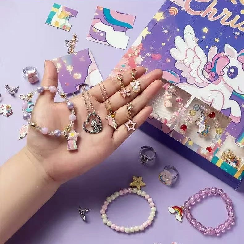 Hand holding various jewelry items with a colorful unicorn-themed advent calendar box in the background