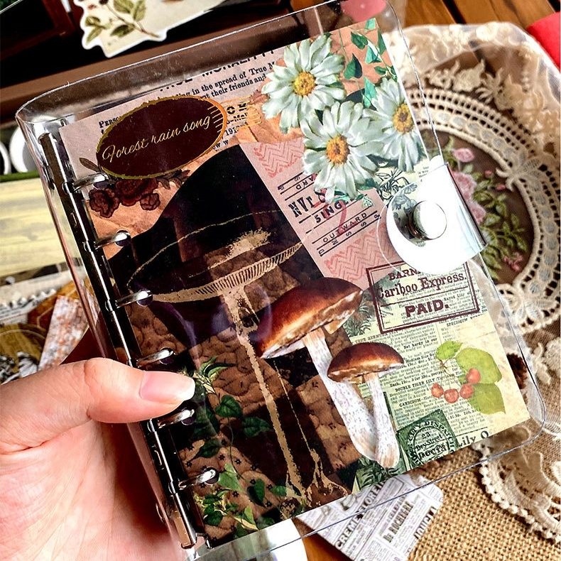 notebook with vintage-style design held by a hand in a DIY Journaling Kit