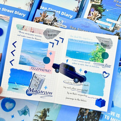 Open journal book with blue and white stickers featuring a car and text, surrounded by other similar books.