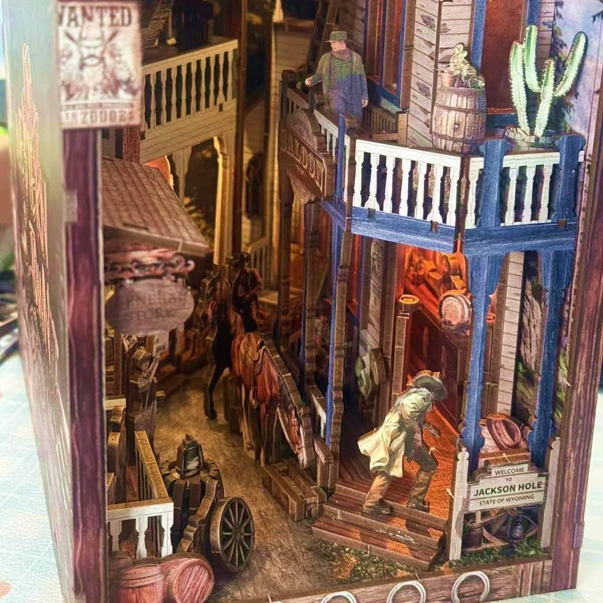 Detailed book nook model of a western town scene with people and buildings.