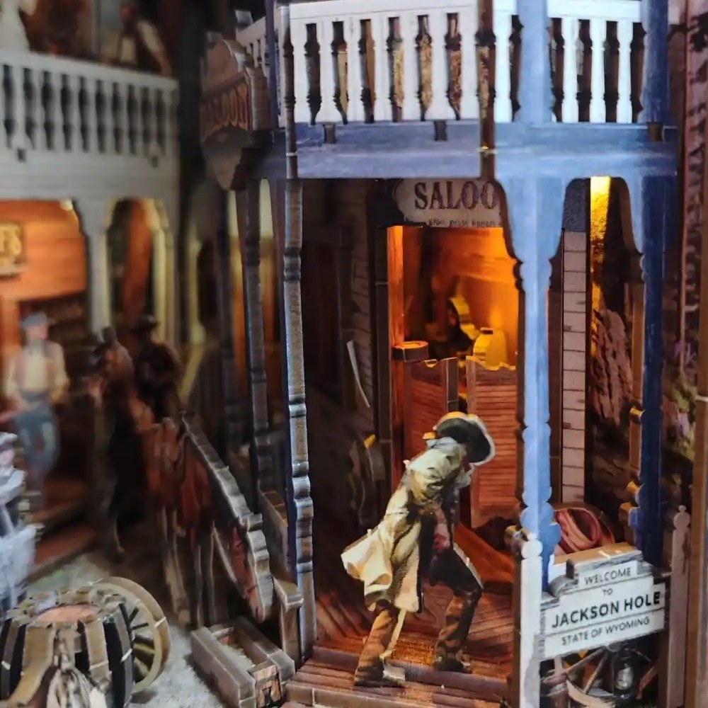 Book Nook Model with a cowboy figure exiting, surrounded by wooden furniture and decor.