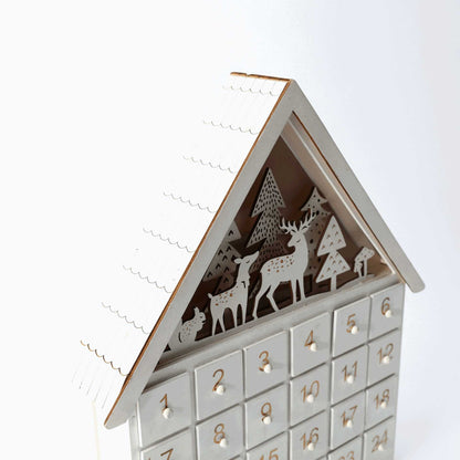 White Forest wooden Christmas Countdown Advent Calendar with 24 drawers, featuring charming forest elements like deer, squirrels, mushrooms, and snow-dusted trees