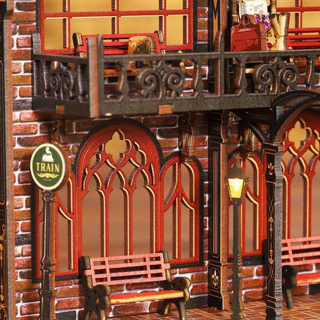 Detailed miniature model of a train station with brick walls, wooden benches, and decorative elements.