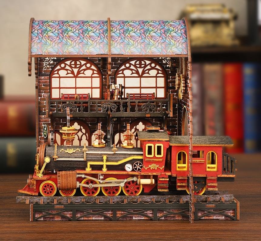 Detailed miniature model train set with stained glass roof on a wooden platform