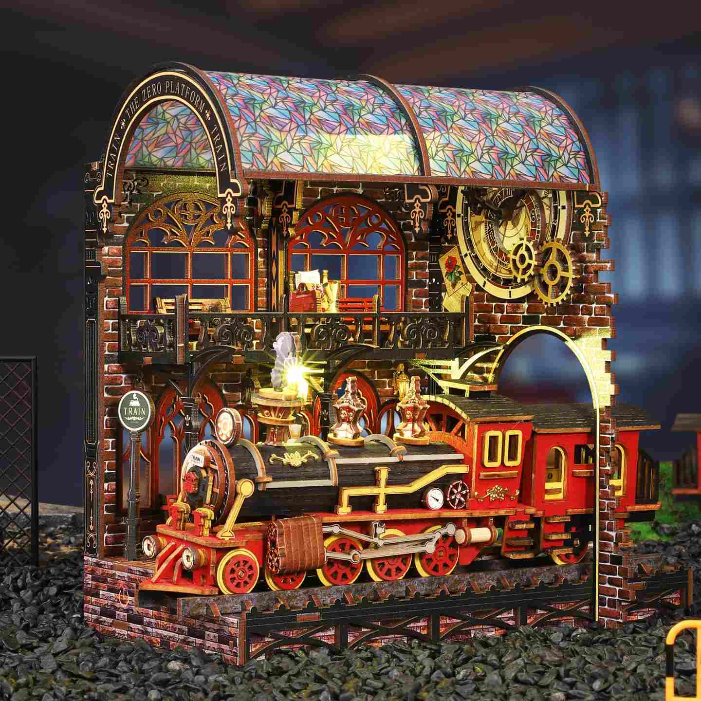 Detailed model train set in book nook with colorful stained class roof and intricate design on a dark background