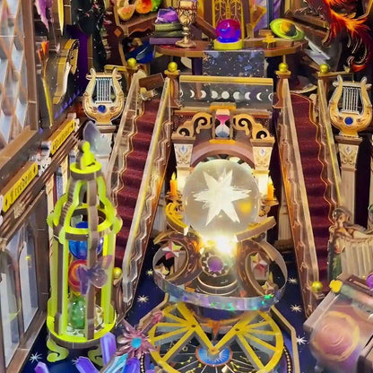 Colorful and intricate diorama model of a fantasy scene with a crystal ball and musical instruments.